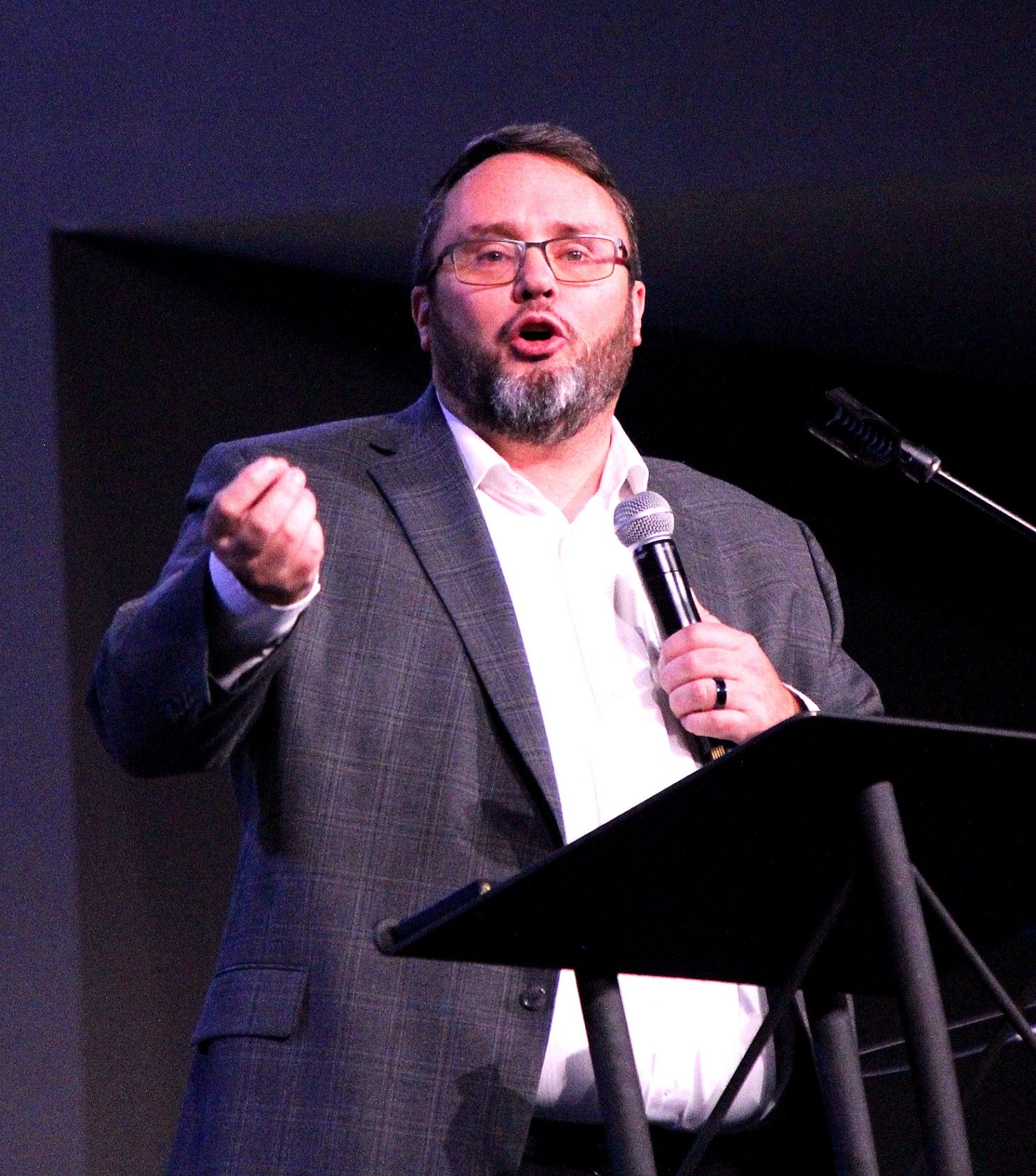 Chris Gardner — Legacy Shift speaking on stage in a gray plaid coat, Arkos Global Advisors in Georgia, TEDx The Myth of Scarcity, Check What You Are Chasing